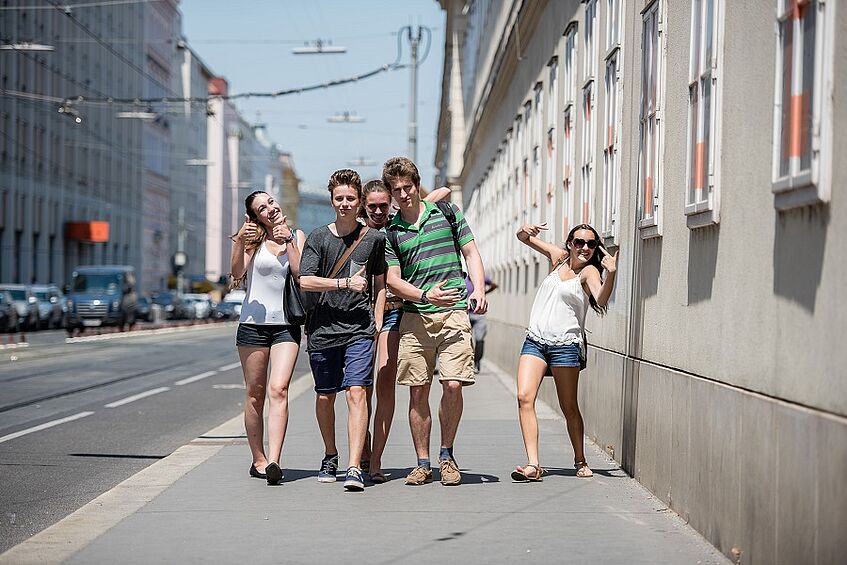 Studierendengruppe die in der Stadt spaziert.