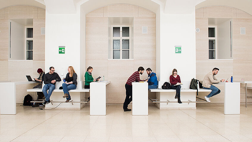 Students sitting with books and standing in a student space provided by the university