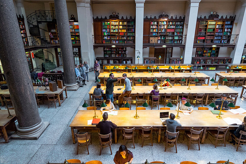 Students studying in the large reading room of the main library.