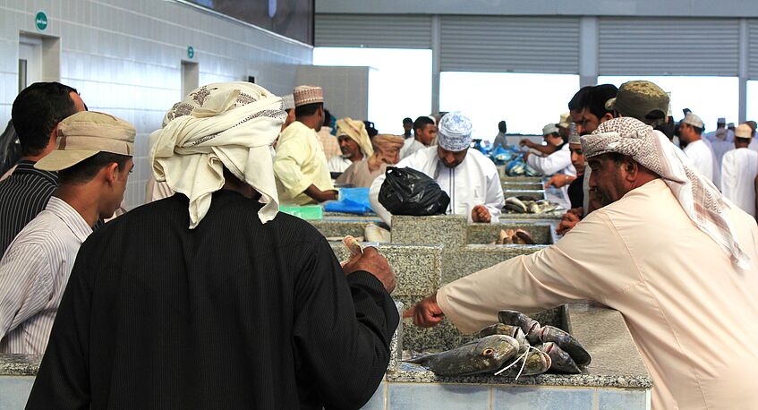 Men bargaining at an Arab fish market.