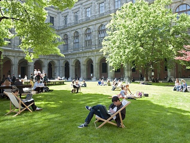 Students sitting on the lawn inside the university building.