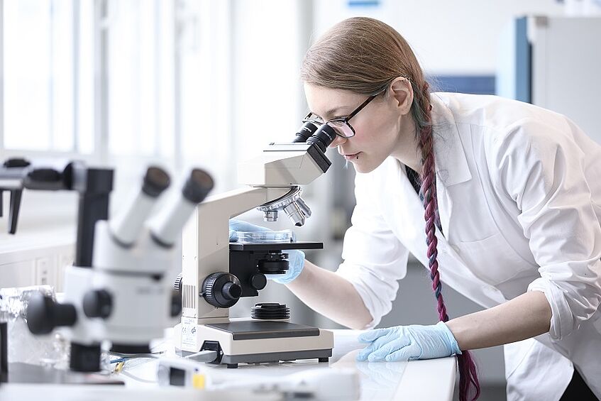 Student looking through a microscope.