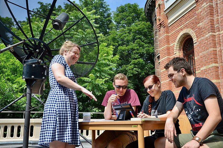 Students are sitting in front of an observatory.