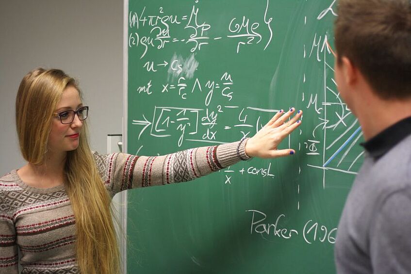 Two students looking at a blackboard.