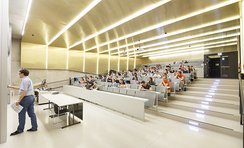 Hörsaal in der Währinger Straße 29 mit Lehrendem und Studierenden.