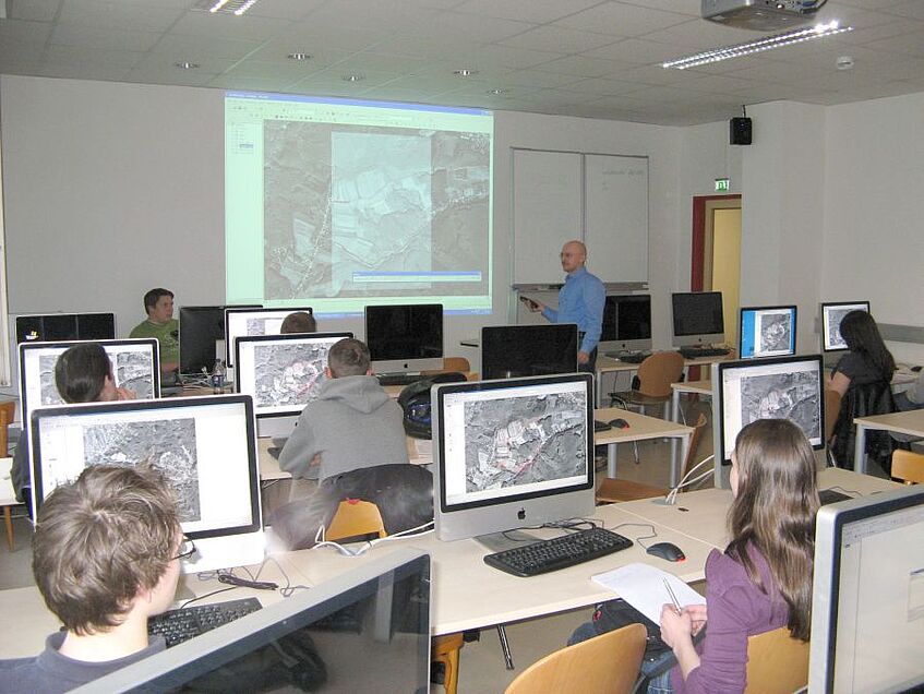 Studierende in einem Computerraum während eines Vortrags.