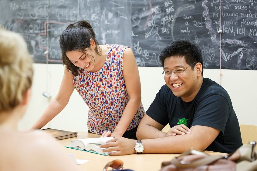 Two students are looking at a book.
</p>
<p>