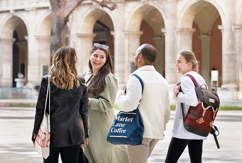 Students talking to each other at the Arcaded Courtyard of the main building.