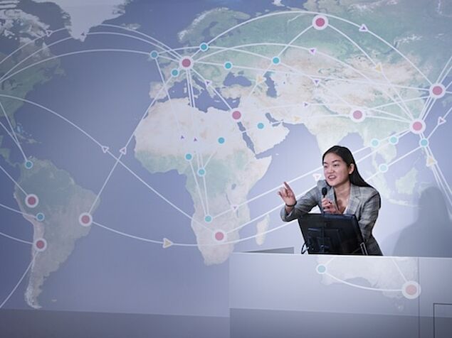student giving a talk in front of a world map