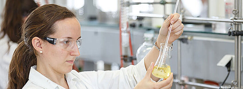 scientist with a laboratory flask in her hand