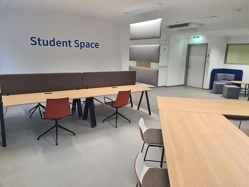 Student Space am Oskar-Morgenstern-Platz 1 mit mehreren Tischen und Sitzgelegenheiten.