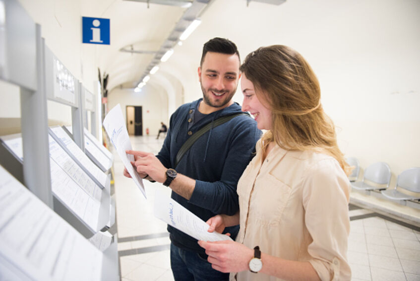 Studierende lesen ein Informationsblatt über das Studienangebot an der Unviersität Wien