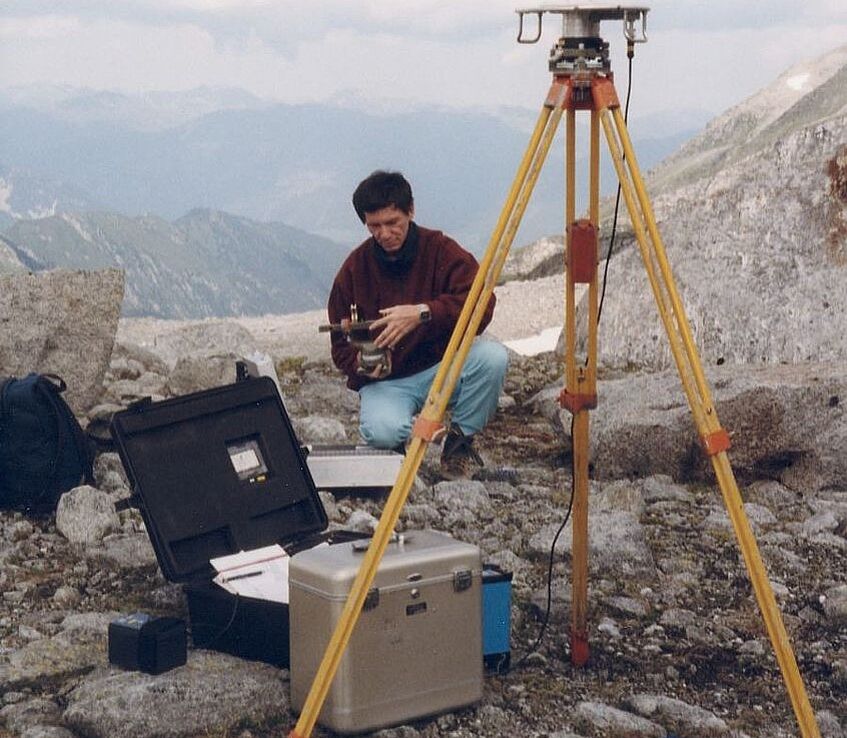 Photo shows surveyor with equipment.